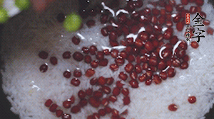將炒好的食材和大米、紅豆一起放進(jìn)電飯鍋煮。
