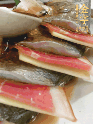 魚肚中塞蔥結(jié)、火腿片，魚身上碼放姜片、火腿片，倒入混合的料汁。